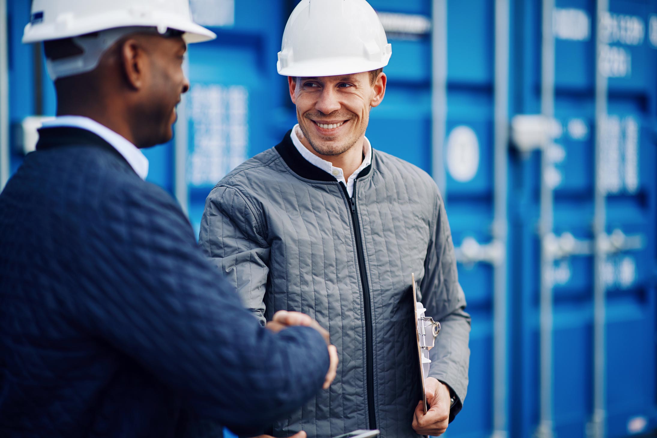 Two workman smiling and shaking hands